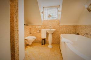 La salle de bains est pourvue d'une baignoire, d'un lavabo et de toilettes. dans l'établissement Villa Beukenhof, à Oegstgeest