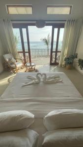 1 dormitorio con 1 cama grande y vistas al océano en Lihinya Beach Villa Ahangama en Ahangama