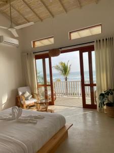 a bedroom with a bed and a view of the ocean at Lihinya Beach Villa Ahangama in Ahangama