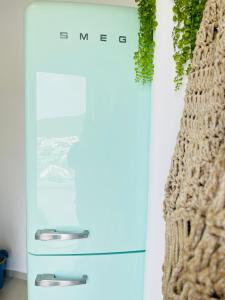 a blue refrigerator in a kitchen with a plant at Gerani Deluxe Houses in Astypalaia