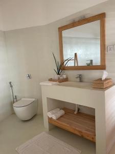 a bathroom with a sink and a toilet and a mirror at Lihinya Beach Villa Ahangama in Ahangama