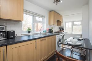 a kitchen with a sink and a dishwasher at Pass the Keys Comfy Apartment by Oval Station in London