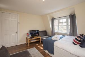 um quarto com uma cama, um sofá e uma janela em Pass the Keys Comfy Apartment by Oval Station em Londres