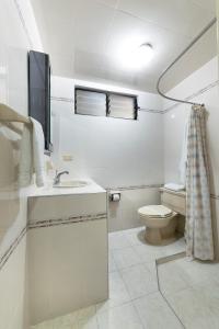 a white bathroom with a toilet and a sink at Hotel Stein Colonial in Cali