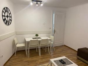 a dining room with a white table and chairs at Lana apartman in Belgrade