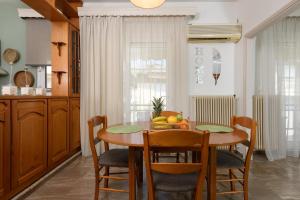 a kitchen with a wooden table with chairs and a dining room at El Nido Apartment in Limenas