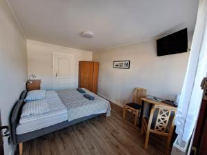 sypialnia z łóżkiem i telewizorem z płaskim ekranem w obiekcie Pokoje Gościnne OAZA w Sztutowie