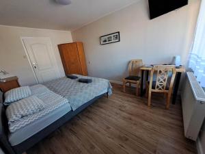 sypialnia z łóżkiem, stołem i biurkiem w obiekcie Pokoje Gościnne OAZA w Sztutowie