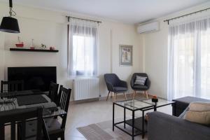 - un salon avec un canapé, une table et des chaises dans l'établissement Alexandros Maisonettes & Apartments, à Nea Moudania