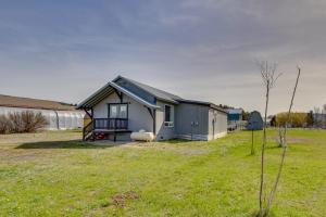 a small house in a field next to a building at Cozy Cle Elum Cabin with 3 Acres and Stocked Pond in Cle Elum