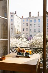 a plate of food on a table on a balcony at Hotel du Théatre in Lyon