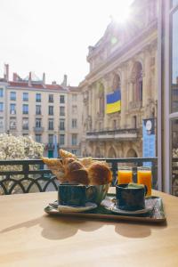 uma bandeja de pão e pastelaria numa mesa em Hotel du Théatre em Lyon