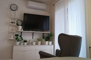 a living room with a flat screen tv and a chair at Plitvice Green Apartment in Plitvička Jezera