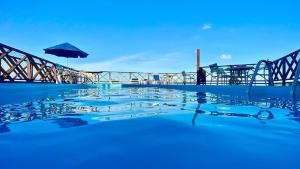 ein Swimmingpool mit einem Sonnenschirm darauf in der Unterkunft Marsallis Flat 305 Praia - NBI - Ponta Negra in Natal