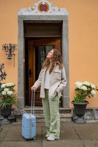 a woman standing in front of a door with a suitcase at CASA BELGERI in Dongio
