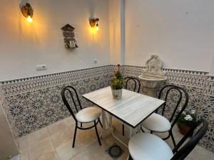 a table with chairs and a vase of flowers on it at La Tesela in Priego de Córdoba