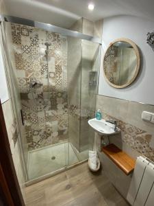 uma casa de banho com um chuveiro, um lavatório e um espelho. em La Tesela em Priego de Córdoba