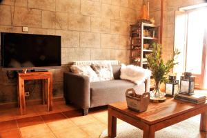 a living room with a couch and a tv at Casa Hijuela in Concejero