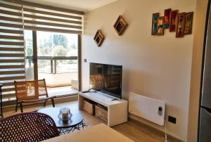 a living room with a large television and a table at Cómodo Departamento en Pucón in Pucón
