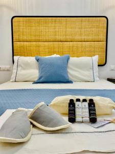 a bed with two pillows and three bottles on it at Gerani Deluxe Houses in Astypalaia