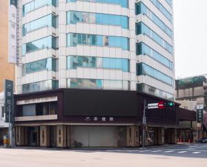 a tall building on a city street with a traffic light at Green Hotel - Tea Way in Taichung