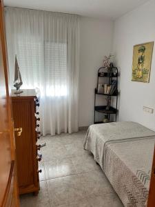 1 dormitorio con 1 cama, vestidor y ventana en Chalet con piscina privada en Vinarós