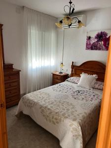 a bedroom with a large bed and a dresser and a lamp at Chalet con piscina privada in Vinarós