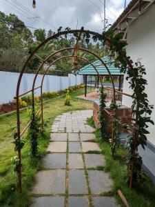 an archway over a stone walkway with a garden at Multiple Stories, Wayanad in Wayanad