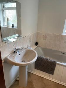 Irvinestown Fermanagh 2 Bedroom Apartment في Irvinestown: حمام مع حوض وحوض استحمام