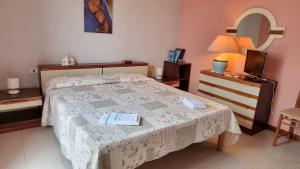 een slaapkamer met een bed met een tafel en een spiegel bij La casa delle rose in Su Forti