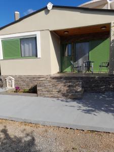 a house with a patio with two chairs on it at Cosmitsa House in Vingláfia