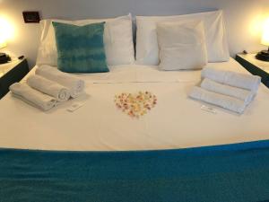een bed met handdoeken en een hart gemaakt van bloemen bij 37 Iseo Lake A&A in Marone