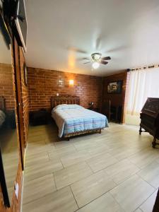 1 dormitorio con cama y pared de ladrillo en Hotel Esperanza, en Lima