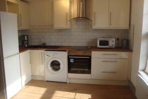 a kitchen with a washing machine and a microwave at Cairo Street in Warrington
