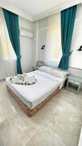 1 dormitorio con 1 cama grande y cortinas azules en Eftelya Apart, en Ölüdeniz