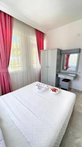 a bedroom with a large white bed with two plates on it at Eftelya Apart in Oludeniz