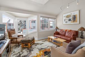 a living room with a couch and chairs and windows at West Willow 5 in Telluride