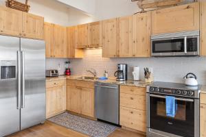 eine Küche mit Holzschränken und Küchengeräten aus Edelstahl in der Unterkunft West Willow 5 in Telluride