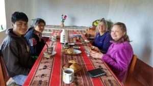 un grupo de personas sentadas en una mesa en Lakeside Luquina, en Puno