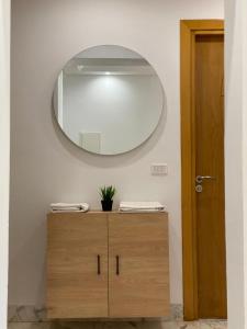 a bathroom with a mirror and a wooden dresser at Appart calme & chaleureux en résidence près de la mer in Monastir