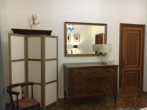 Cette chambre comprend une commode, un miroir et une chaise. dans l'établissement Villamonestevole501, à Umbertide