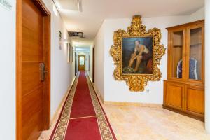 un corridoio con un dipinto sul muro accanto a una porta di Hotel Riad Arruzafa a Cordoba