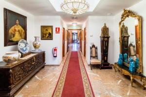 a hallway with vases and art on the walls at Hotel Riad Arruzafa in Córdoba