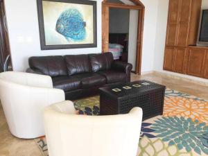 uma sala de estar com um sofá de couro e duas cadeiras em The Dolphins Ocean Front-Beach 2 BR 2Bth em Rosarito