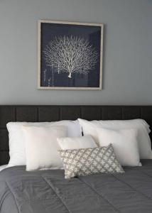 een bed met witte kussens en een foto van een boom bij A Quiet Place in Cincinnati