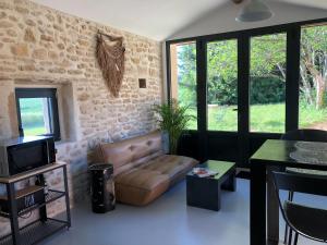 ein Wohnzimmer mit einem Sofa und einem Tisch in der Unterkunft L’atelier in Grane
