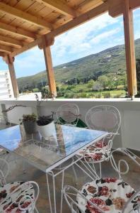 una mesa y sillas en un balcón con vistas en Stellinas Pretty House, en Ándros