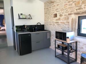 a kitchen with a sink and a microwave at L’atelier in Grane