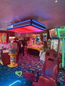 pokój gier z ludźmi grającymi w gry wideo w obiekcie 8 Bed Sun Decked Caravan Unlimited High speed Wifi and fun at Seawick Holiday Park w mieście Clacton-on-Sea