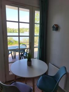 Habitación con mesa, sillas y ventana en Le petit jazz du lac, en Marciac